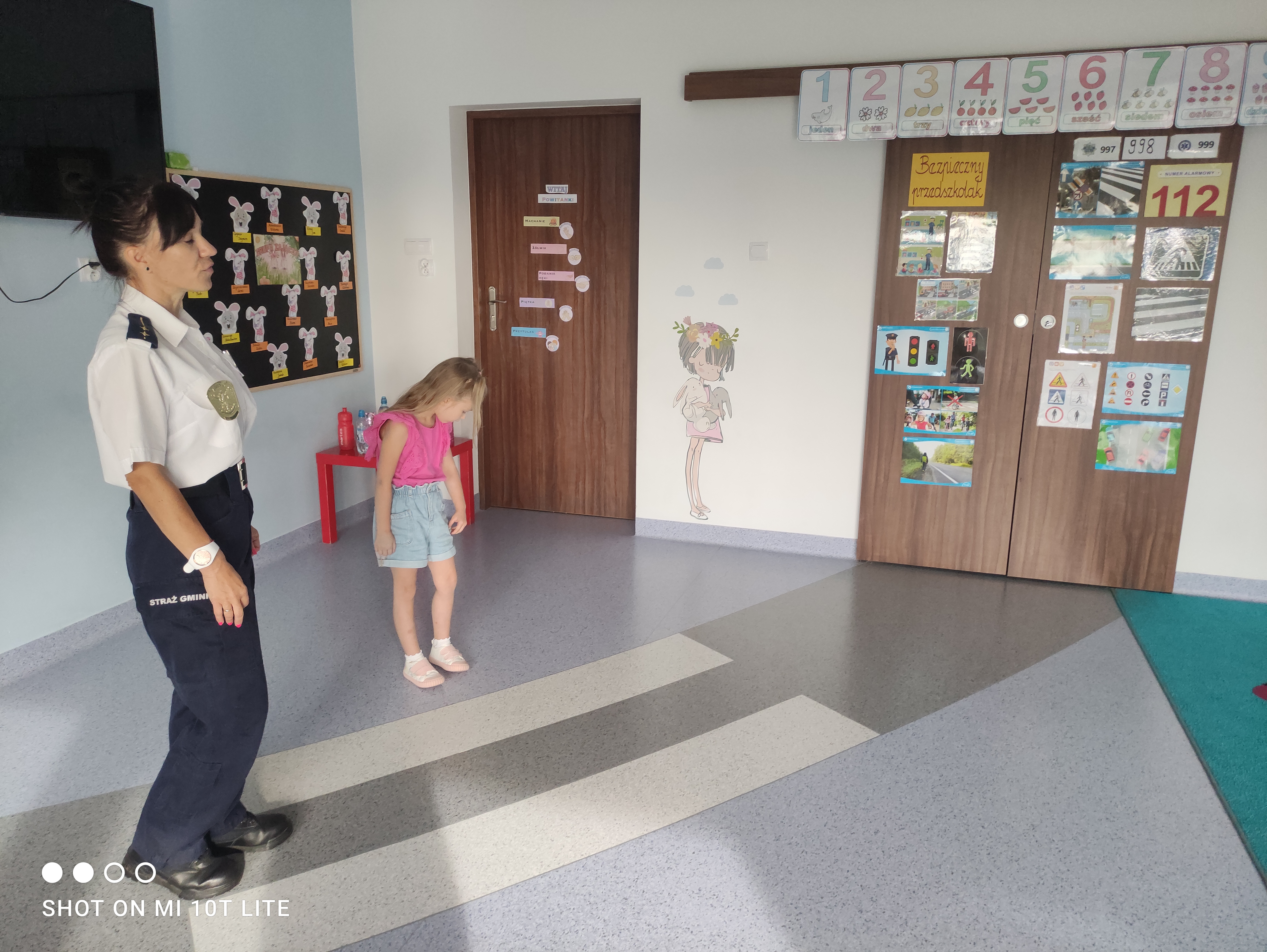 Strażnik gminny przedstawiajcy zasady przejścia przez pasy